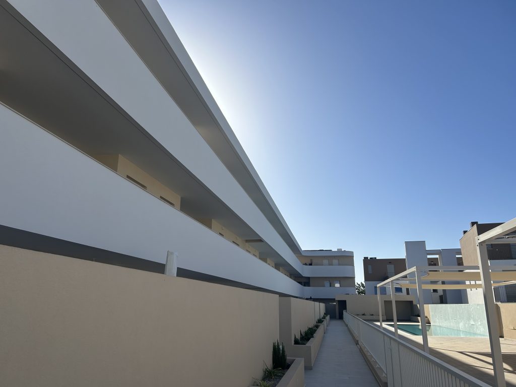 Fachada do conjunto Royal com varandas em fita e piscina ao fundo, Cabanas de Tavira